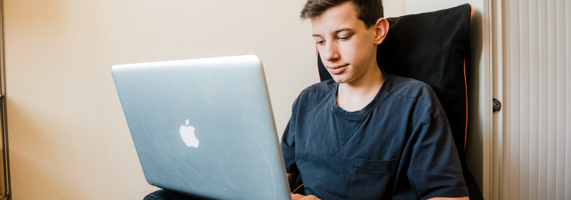 Junge mit Laptop beim Online lernen